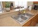 The kitchen features a stainless steel sink, granite countertops, wood cabinets and updated appliances at 13427 Blue Heron Beach Dr # 1607, Orlando, FL 32821