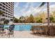 Resort-style pool with lounge chairs, palm trees, and a tall building in the background, perfect for relaxation at 13427 Blue Heron Beach Dr # 1607, Orlando, FL 32821