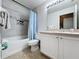 Bright bathroom with a shower-tub combo, tiled walls, and a modern white vanity at 1361 Rebecca Dr, Haines City, FL 33844