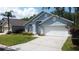 Charming blue single-story home with a well-manicured lawn and attached two-car garage at 1361 Rebecca Dr, Haines City, FL 33844