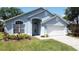 Charming blue single-story home with a well-manicured lawn and attached two-car garage at 1361 Rebecca Dr, Haines City, FL 33844