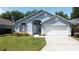 Charming blue single-story home with a well-manicured lawn and attached two-car garage at 1361 Rebecca Dr, Haines City, FL 33844