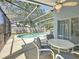 Screened-in patio features a ceiling fan, and views of the pool and landscaped yard at 1361 Rebecca Dr, Haines City, FL 33844