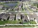 An aerial view shows homes on a street with green lawns, a lake, and landscaping at 1371 Red Blossom Ln, Kissimmee, FL 34746