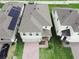 Aerial view of two-story home with brick driveway, attached garage, and manicured landscaping at 1371 Red Blossom Ln, Kissimmee, FL 34746