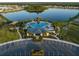 An aerial view displays a community pool, clubhouse, and surrounding landscaping at 1371 Red Blossom Ln, Kissimmee, FL 34746