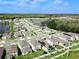 Aerial view of a community with a tranquil pond surrounded by modern homes at 1371 Red Blossom Ln, Kissimmee, FL 34746
