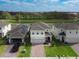 An elevated view of a traditional suburban home with brick drive, green lawn, and neighboring houses at 1371 Red Blossom Ln, Kissimmee, FL 34746