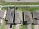 View of homes, solar panels, and green lawns on an attractively landscaped street at 1371 Red Blossom Ln, Kissimmee, FL 34746