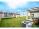 Expansive backyard featuring a trampoline, playset, patio, and an air conditioning unit at 1371 Red Blossom Ln, Kissimmee, FL 34746