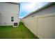 Spacious fenced backyard with green lawn, air conditioner, and view of neighboring houses at 1371 Red Blossom Ln, Kissimmee, FL 34746