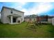 Large backyard featuring a covered patio, playset, trampoline, and lush green grass at 1371 Red Blossom Ln, Kissimmee, FL 34746