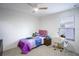 Bright bedroom with carpet, a ceiling fan, a bed with modern bedding, and a study desk at 1371 Red Blossom Ln, Kissimmee, FL 34746