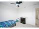 Cozy bedroom with carpet, a ceiling fan, a bed with colorful bedding, and a changing table at 1371 Red Blossom Ln, Kissimmee, FL 34746