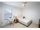 Well-lit bedroom featuring carpet, a ceiling fan, a bed with modern bedding, and a study desk at 1371 Red Blossom Ln, Kissimmee, FL 34746