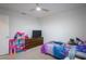 Bright bedroom with carpet, a ceiling fan, a bed with modern bedding, and a doll house at 1371 Red Blossom Ln, Kissimmee, FL 34746