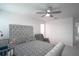A spacious bedroom with a patterned bedspread, ceiling fan and neutral tones at 1371 Red Blossom Ln, Kissimmee, FL 34746
