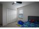 Well-lit bedroom featuring carpet, a ceiling fan, and a bed with colorful bedding at 1371 Red Blossom Ln, Kissimmee, FL 34746