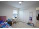 Bright bedroom with carpet, a ceiling fan, a bed with modern bedding, and a study desk at 1371 Red Blossom Ln, Kissimmee, FL 34746