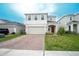 Charming two-story home with a brick driveway, well-manicured lawn, and a two-car garage at 1371 Red Blossom Ln, Kissimmee, FL 34746