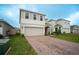 Attractive two-story home with brick driveway, two-car garage, and well-maintained landscaping at 1371 Red Blossom Ln, Kissimmee, FL 34746