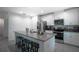 Modern kitchen featuring an island with seating, stainless steel appliances, and white cabinets at 1371 Red Blossom Ln, Kissimmee, FL 34746