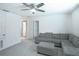 Living room featuring a couch, carpeted floor, and a ceiling fan at 1371 Red Blossom Ln, Kissimmee, FL 34746