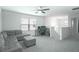 Carpeted living room featuring a ceiling fan, couch, and an office desk at 1371 Red Blossom Ln, Kissimmee, FL 34746