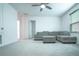 Spacious living room area with carpet, couch, and ceiling fan at 1371 Red Blossom Ln, Kissimmee, FL 34746