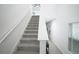 Carpeted staircase with white railing and tile floors, leading to upper level of home at 1371 Red Blossom Ln, Kissimmee, FL 34746