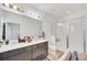 Bright bathroom features a double vanity, and a modern shower with sleek glass doors and tile at 15687 Kinnow Mandarin Ln, Winter Garden, FL 34787