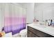 Bright bathroom with neutral walls, a vanity, a large mirror, toilet and shower with privacy curtain at 15687 Kinnow Mandarin Ln, Winter Garden, FL 34787
