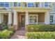 Inviting front porch featuring brick pathway, lush landscaping, and Craftsman-style columns at 15687 Kinnow Mandarin Ln, Winter Garden, FL 34787