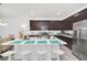 Modern kitchen boasts a large island with seating, stainless steel appliances, and dark wood cabinets at 15687 Kinnow Mandarin Ln, Winter Garden, FL 34787