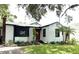 Charming single-story home with a red door, well-maintained lawn, and complemented by lush landscaping at 204 E Harvard St, Orlando, FL 32804