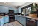 Modern kitchen featuring blue cabinets, stainless steel appliances, and black backsplash at 204 E Harvard St, Orlando, FL 32804