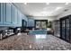 Bright kitchen featuring blue cabinets, stainless steel appliances, and a granite island at 204 E Harvard St, Orlando, FL 32804