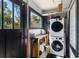 Practical laundry room with stacked washer and dryer, natural light, and functional workspace at 204 E Harvard St, Orlando, FL 32804