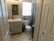 Bathroom features a single sink vanity, toilet, gray shower curtain, and tiled floors at 2160 Addison Ave, Clermont, FL 34711