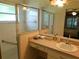 Bathroom vanity with single sink, cabinets, and walk-in shower with glass doors and grab bar at 2160 Addison Ave, Clermont, FL 34711