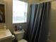 Bathroom featuring a sink, toilet and shower curtain next to a bright, window at 2160 Addison Ave, Clermont, FL 34711