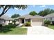 Charming single Gathering home with a well-manicured lawn, brick driveway, and two-car garage at 2160 Addison Ave, Clermont, FL 34711