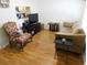 Cozy living room features wood floors, comfortable seating, and a TV for entertainment at 2160 Addison Ave, Clermont, FL 34711