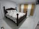 A spacious bedroom with a dark wood poster bed and white tile flooring at 2211 New Jersey Rd, Lakeland, FL 33803