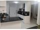 Open-concept kitchen with black countertops, white cabinetry, and stainless steel appliances at 2211 New Jersey Rd, Lakeland, FL 33803