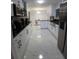 Modern kitchen boasts sleek white cabinets, stainless steel appliances, and elegant marble floors at 2211 New Jersey Rd, Lakeland, FL 33803