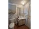 Compact bathroom with floral wallpaper, vanity, and toilet at 222 Palmer Park Ln, Davenport, FL 33897