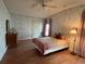 Cozy bedroom featuring floral wallpaper, wood-look floors, ceiling fan, and lots of natural light at 222 Palmer Park Ln, Davenport, FL 33897