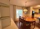 Bright dining room with laminate floors, chandelier, and view of the kitchen with black appliances at 222 Palmer Park Ln, Davenport, FL 33897