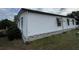 Exterior of the home showing the white siding with brick-look foundation and manicured lawn at 222 Palmer Park Ln, Davenport, FL 33897
